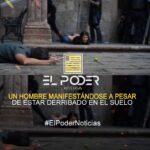 Un hombre manifestándose a pesar de estar derribado en el suelo